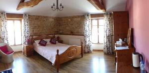 um quarto com uma cama num quarto com janelas em Au clair du soleil em Saint-Juire-Champgillon