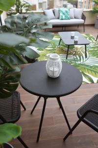 a black table with a vase sitting on top of it at Glass Boutique - Rooms & Suites in Marinha Grande