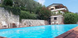 a swimming pool with chairs and a building at casa amigo in Padenghe sul Garda