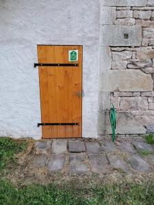 een houten deur aan de zijkant van een gebouw bij Gîte des Planches Le Pit in Saint-Bresson