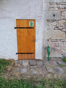 Gîte des Planches Le Pit في Saint-Bresson: باب خشبي على جانب المبنى