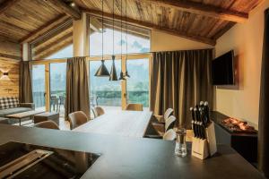 a dining room with a table and a large window at Rufana Alpin in Bürserberg