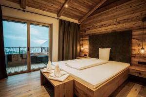 a bedroom with a large bed and a large window at Rufana Alpin in Bürserberg