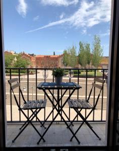 einen Tisch mit zwei Stühlen und eine Topfpflanze auf dem Balkon in der Unterkunft Descalzos Apartment - Old Town in Tarragona