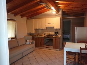 sala de estar con sofá y cocina en Il carpino bianco bilocale, en Puegnago sul Garda