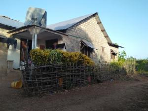 une vieille maison en briques entourée d'une clôture dans l'établissement Wasini Raha Snorkeling and Diving, à Wasini