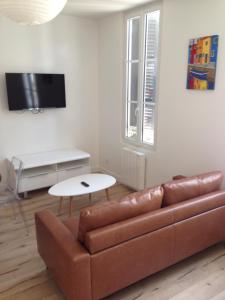 ein Wohnzimmer mit einem Sofa und einem Tisch in der Unterkunft Joli appartement 40m2 entièrement équipé idéal pour location thermale ou saisonnier in Rochefort