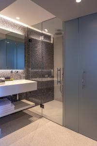 a bathroom with a sink and a glass shower at Skiathos Palace Hotel in Koukounaries