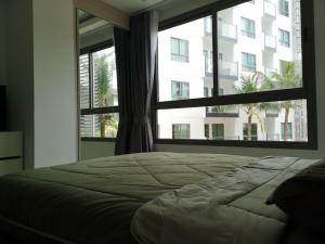 um quarto com uma cama e uma janela grande em 2BDR in Water Resort close to WalkingStreet em Pattaya Sul