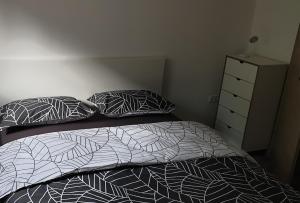 ein Schlafzimmer mit einem Bett, zwei Kissen und einer Kommode in der Unterkunft APARTMAJI VITEZ in Bovec