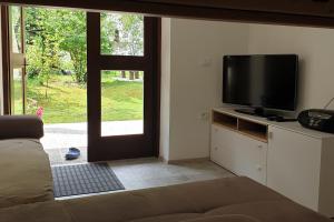 ein Wohnzimmer mit einem Flachbild-TV und einem Fenster in der Unterkunft APARTMAJI VITEZ in Bovec