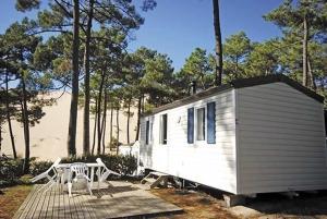 a small white house sitting on top of a wooded area at Pyla Camping in Pyla-sur-Mer