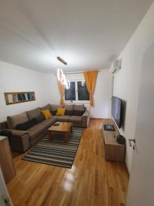 un soggiorno con un divano e un tavolo di Apartman Lux Doboj a Doboj