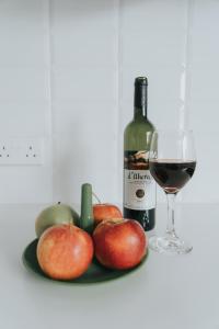 a plate of apples and a glass of wine at Prima Gardens City Studios in Larnaca
