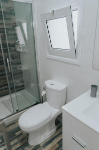 a bathroom with a toilet and a glass shower at Prima Gardens City Studios in Larnaka