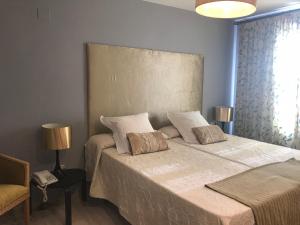 
a bedroom with a bed and a lamp at Hotel Patilla Ciudad de Requena in Requena
