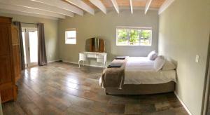 a bedroom with a bed and a table and a window at The Barn in Franschoek in Franschhoek