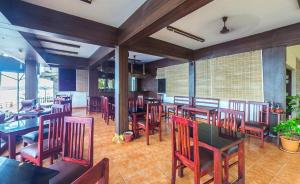 a dining room with tables and chairs in a restaurant at The Ocean Park Beach Resort in Kovalam