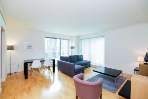 a living room with a couch and a table and chairs at Horizon Canary Wharf Apartments in London
