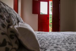 a bedroom with a bed and a red door at Hacienda Venecia Coffee Farm Hotel in Manizales