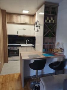 cocina con barra y 2 taburetes en Apartman Lux Doboj en Doboj