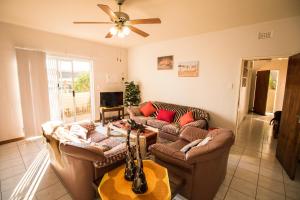 una sala de estar con 2 sofás y una guitarra en John-Lou's One-bedroom Apartment, en Windhoek