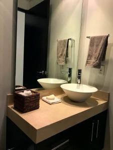 a bathroom with two sinks and a large mirror at Room In Residential WTC in Mexico City