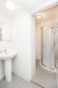 W łazience znajduje się prysznic i umywalka. w obiekcie Maple Street Apartments w Londynie