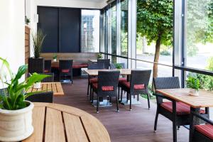 ein Restaurant mit Tischen, Stühlen und Fenstern in der Unterkunft Hotel Rieth in Böblingen