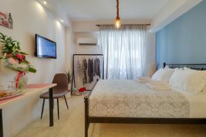 una camera con letto, scrivania e TV di Stylish, Comfy Suite in the Heart of Athens ad Atene