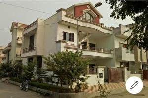 uma grande casa branca com uma árvore em frente em Angad home fully furnished Ac wifi included ground floor em Kharar