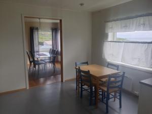 a dining room with a table and chairs and a window at Søndre Berg gate 20 Apartement in Vardø