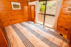 um quarto com uma cama em frente a uma janela em Kunigami-gun - House / Vacation STAY 42281 em Onna