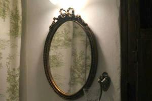 a mirror hanging on a wall next to a curtain at B&B del Giglio in Cefalù
