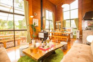 uma sala de estar com uma mesa, cadeiras e janelas em Kunigami-gun - House / Vacation STAY 42281 em Onna