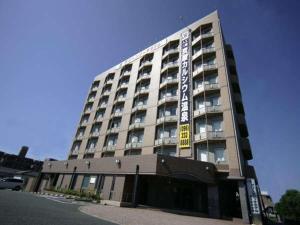 a large building with a sign on the side of it at Green Rich Hotel Aso Kumamoto Airport (Artificial hot spring Futamata Yunohana) in Kikuchi