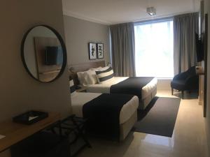 a hotel room with two beds and a mirror at Agua del Corral Hotel & Spa in Mendoza