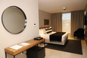 a hotel room with a bed and a mirror at Agua del Corral Hotel & Spa in Mendoza