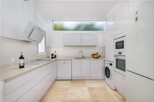 a white kitchen with a sink and a dishwasher at Villa Deluxe Suites Maspalomas in Maspalomas