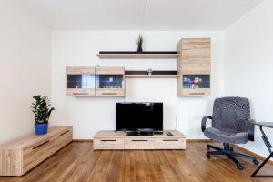 ein Wohnzimmer mit einem TV, einem Schreibtisch und einem Stuhl in der Unterkunft City Center Apartment - Mardi st., FREE Parking!!! in Tallinn