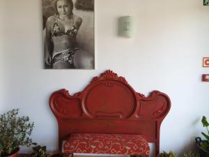 um banco vermelho num quarto com uma foto de uma mulher em El Rincón de la ESPE em Albalate de Zorita
