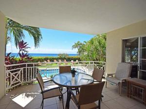 基督教堂市Beachfront Apartment in St. Lawrence Gap - Close To Your Every Need的带桌椅的露台和大海