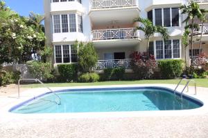 基督教堂市Beachfront Apartment in St. Lawrence Gap - Close To Your Every Need的建筑物前的游泳池
