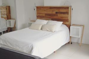 1 dormitorio con cama blanca y cabecero de madera en Paraguay Apartment en Buenos Aires