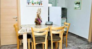 a dining room table with chairs and a white refrigerator at Cristi Apartments in Skala Rachoniou