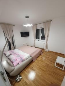 una piccola camera con letto e televisore di Apartman Lux Doboj a Doboj