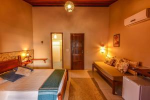 a bedroom with a bed and a desk in a room at Pousada Halai in Morro de São Paulo