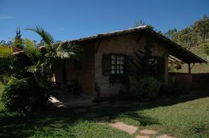 a small brick house with a palm tree in front of it at Chalés de Minas Hotel Fazenda in Caxambu