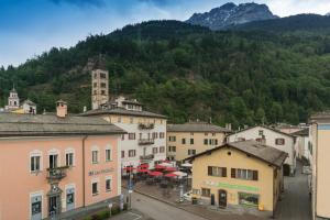 eine Stadt mit Gebäuden und einem Berg im Hintergrund in der Unterkunft Poschiavo Suisse Hotel in Poschiavo