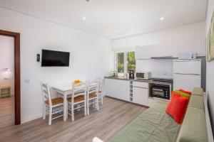 a kitchen and living room with a couch and a table at Apartamentos Flor da Laranja, Albufeira in Albufeira